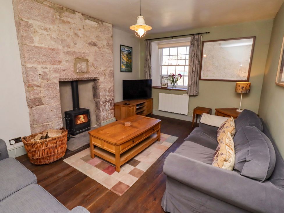 A living room with a fireplace and sofa at Gamekeepers Cottage Chillingham near Chatton