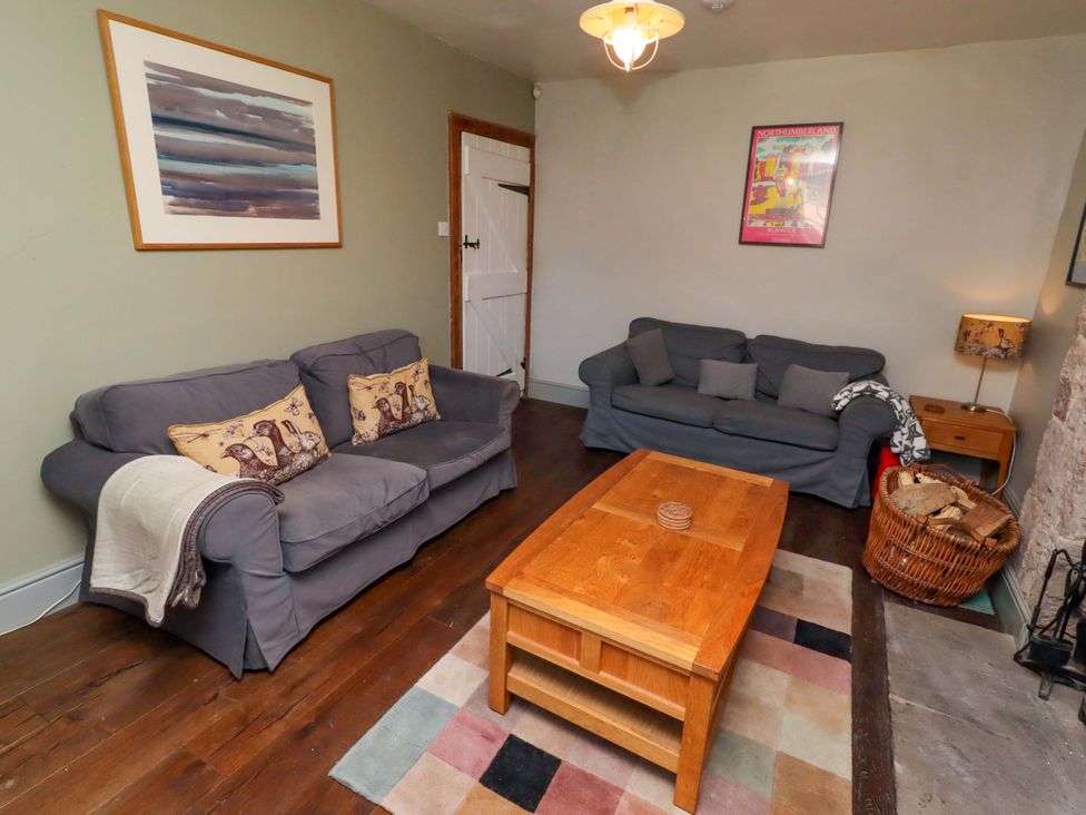 A living room with a coffee table and two sofas at Gamekeepers Cottage in Chillingham near Chatton