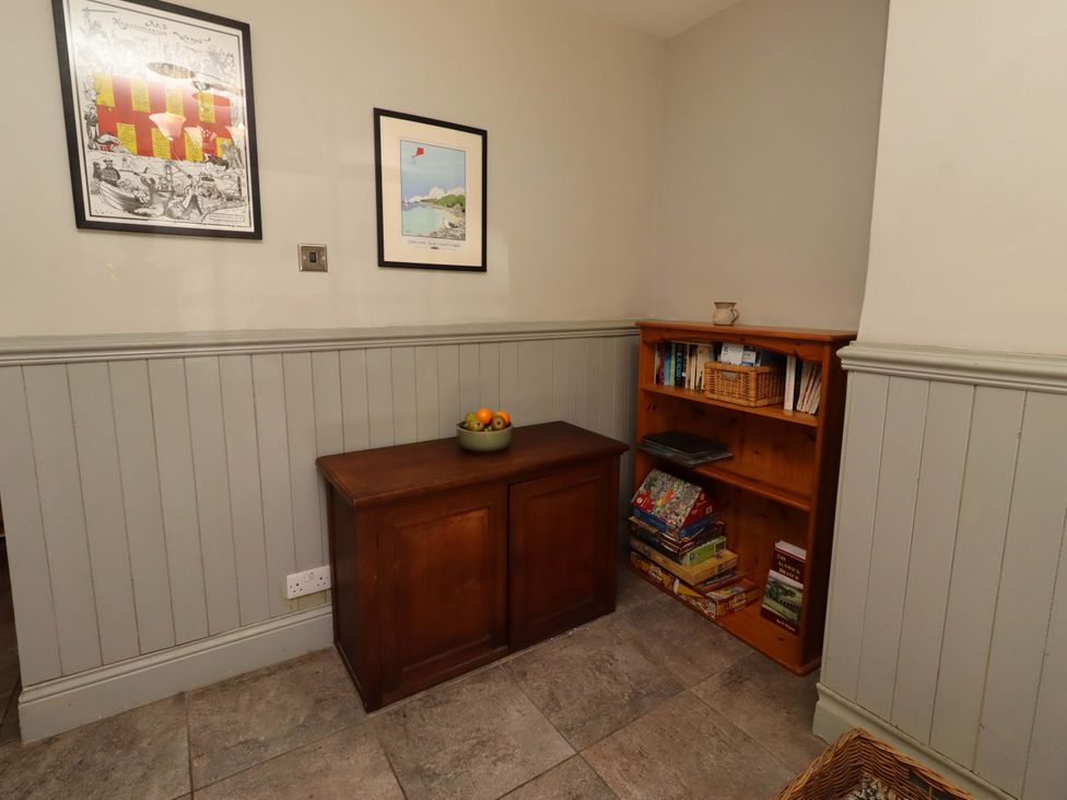A hallway with a wooden chest and shelf at Gamekeepers Cottage in Chillingham near Chatton