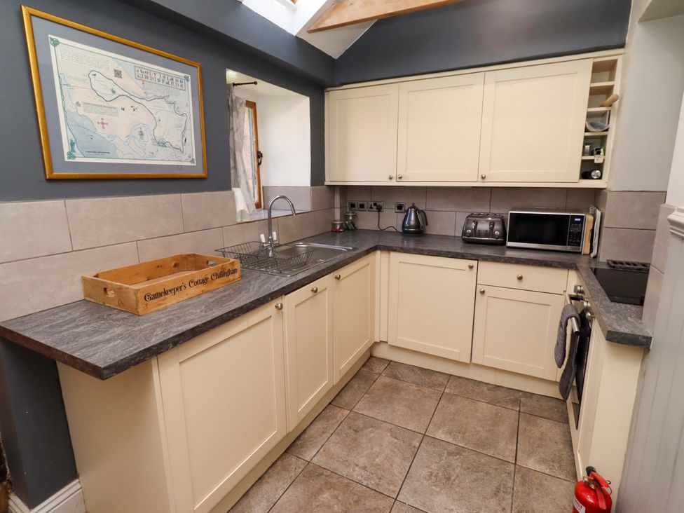 A kitchen with a sink and appliances at Gamekeepers Cottage Chillingham near Chatton