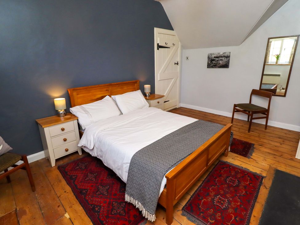 A bedroom with a bed and bedside table at Gamekeepers Cottage in Chillingham near Chatton