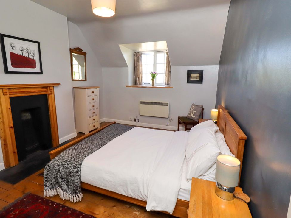 A bedroom with a bed and nightstand at Gamekeepers Cottage in Chillingham near Chatton