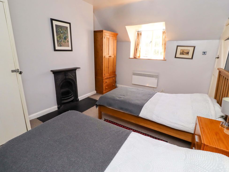 A bedroom with two beds and a chest of drawers at Gamekeepers Cottage in Chillingham near Chatton