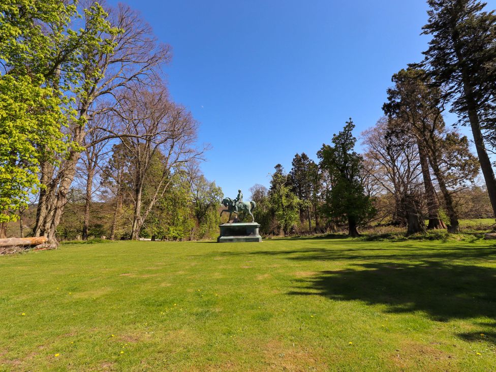 A statue on grass with trees in the background at Gamekeepers Cottage Chillingham near Chatton