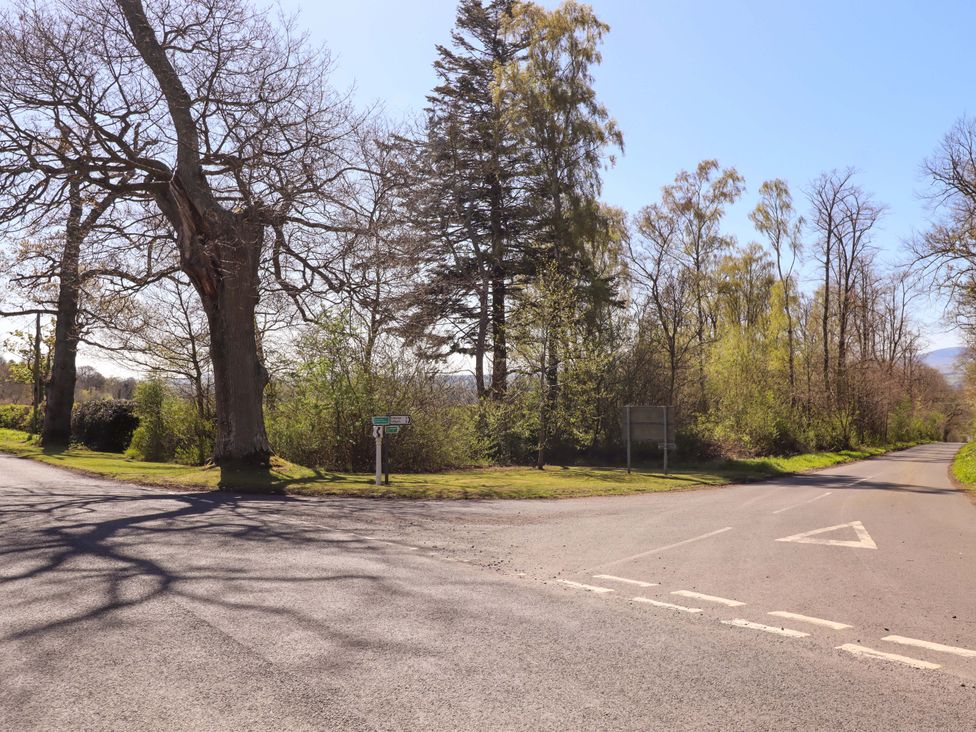 A road junction surrounded by trees and grass at Gamekeepers Cottage Chillingham near Chatton