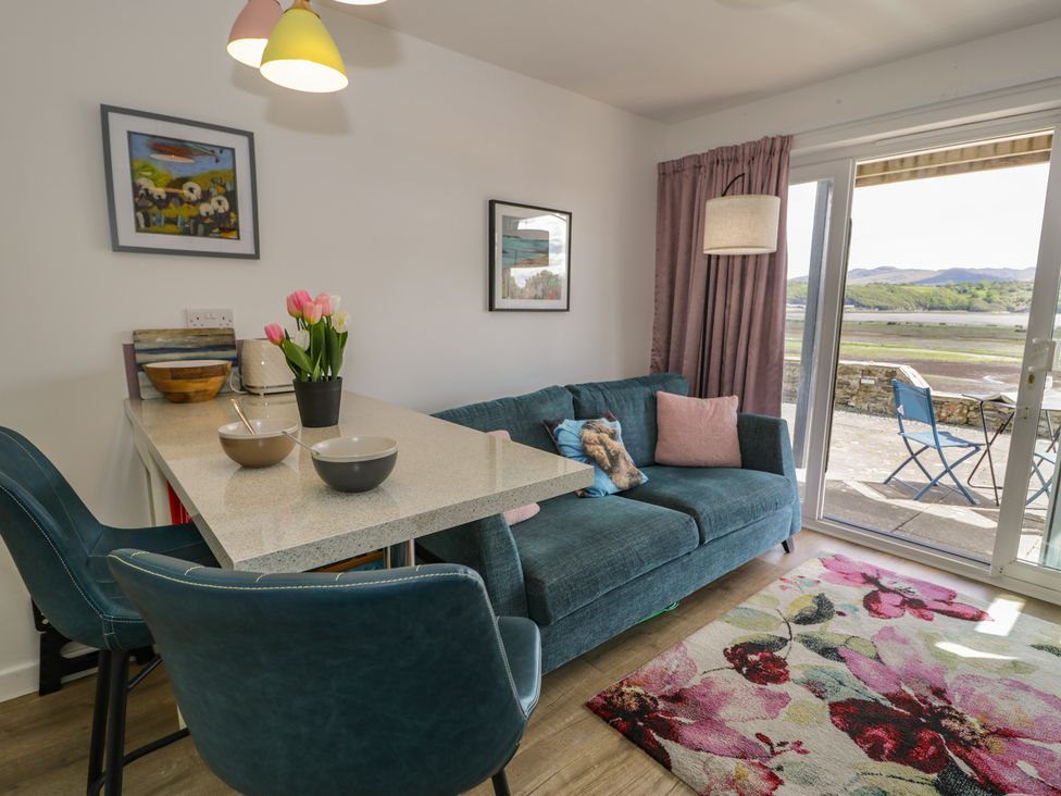 A living room with a sofa and table at Lan y Mor in Porthmadog