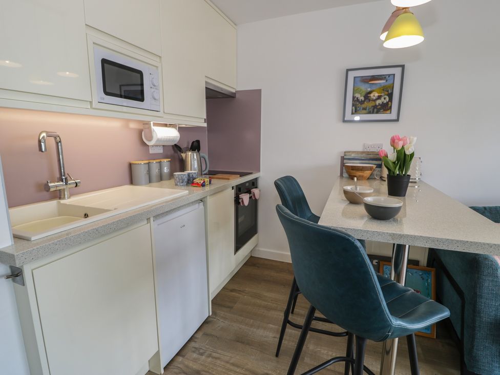A kitchen with a sink and stove at Lan y Mor in Porthmadog