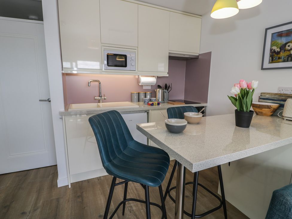 A kitchen with a sink and microwave at Lan y Mor in Porthmadog