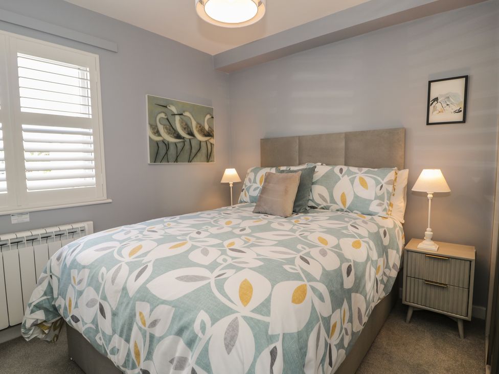 A bedroom with a bed and nightstand at Lan y Mor in Porthmadog