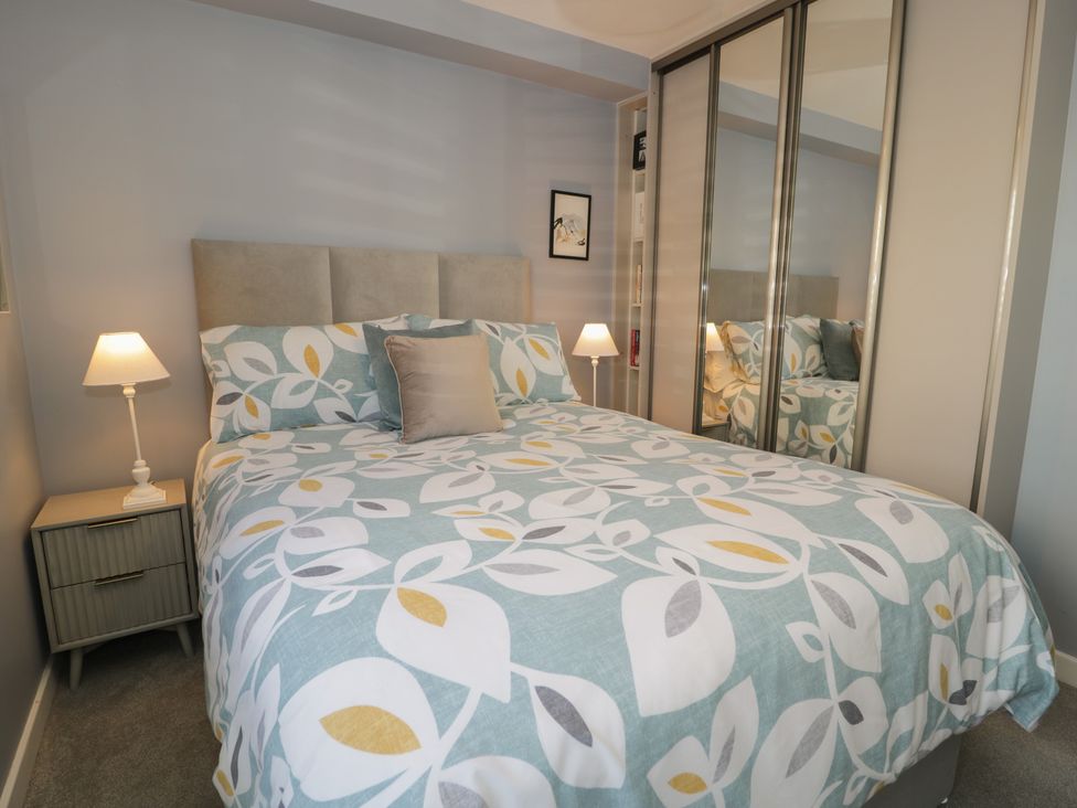 A bedroom with a bed and wardrobe at Lan y Mor, Porthmadog