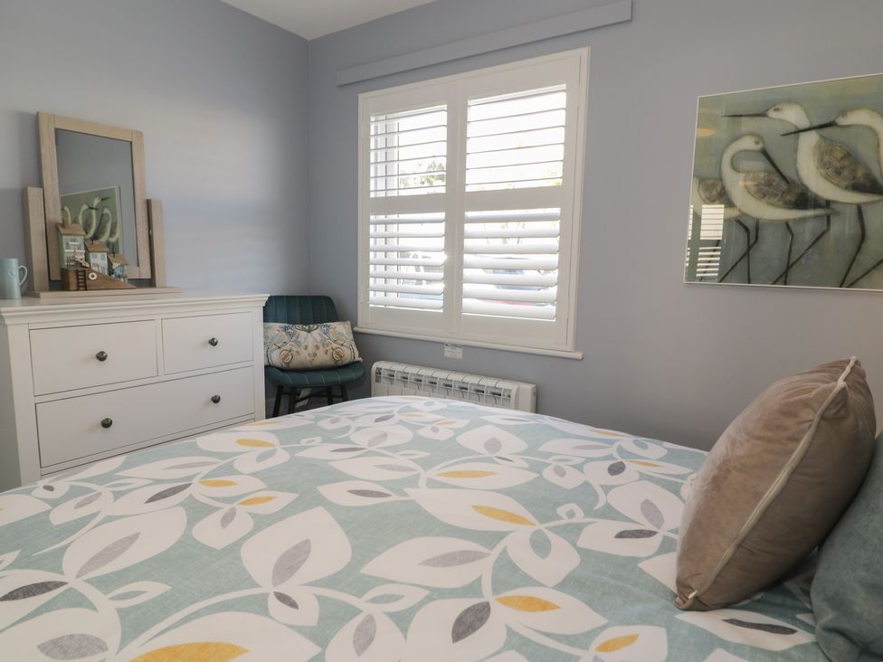 A bedroom with a bed and chest of drawers at Lan y Mor in Porthmadog