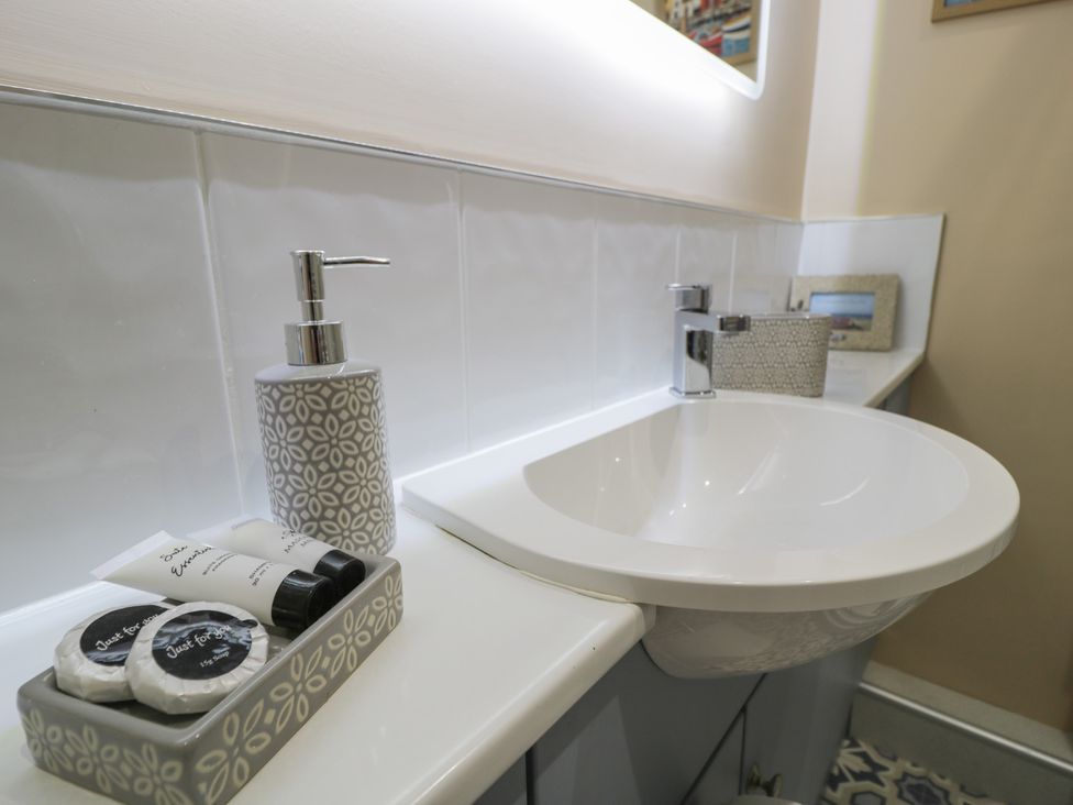 A bathroom with a sink and toiletries at Lan y Mor in Porthmadog