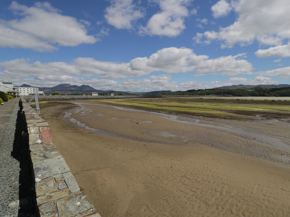 A view of the beach with sand and water at Lan y Mor in Porthmadog