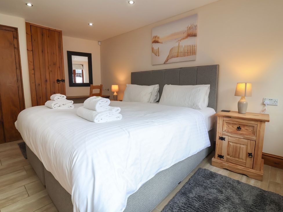 A bedroom with a large bed and towels at The Old Byres in Washford near Watchet