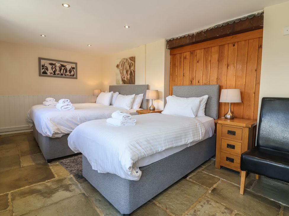 A bedroom with two beds and nightstands at The Old Byres in Washford near Watchet