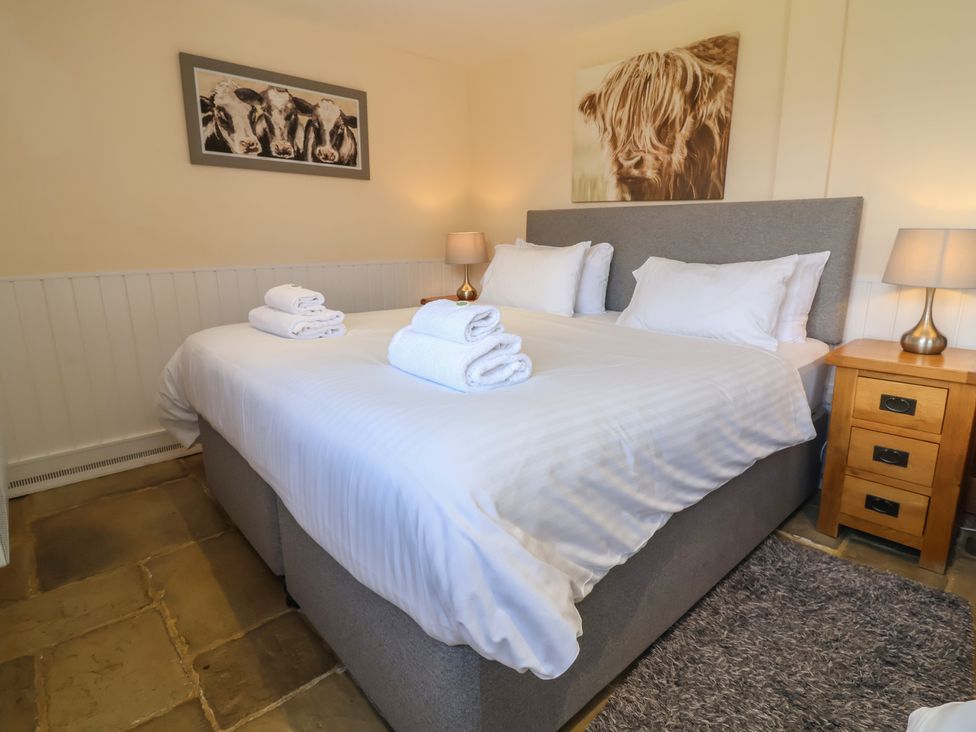A bedroom with a bed and two lamps at The Old Byres in Washford near Watchet