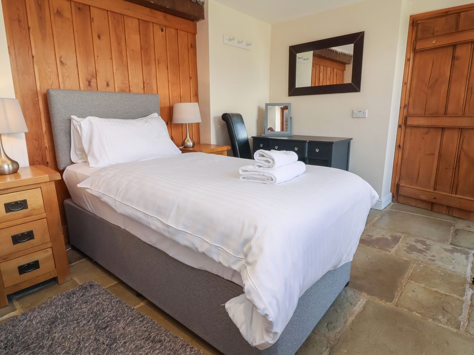 A bedroom with a single bed and bedside table at The Old Byres in Washford near Watchet