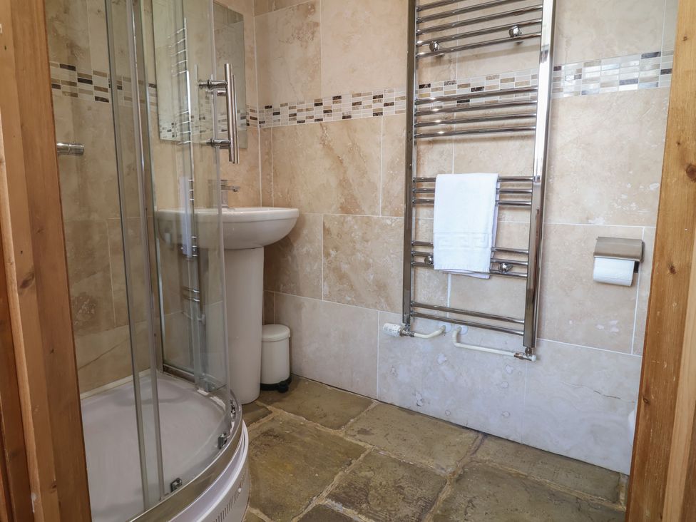A bathroom with a shower and sink at The Old Byres Washford near Watchet