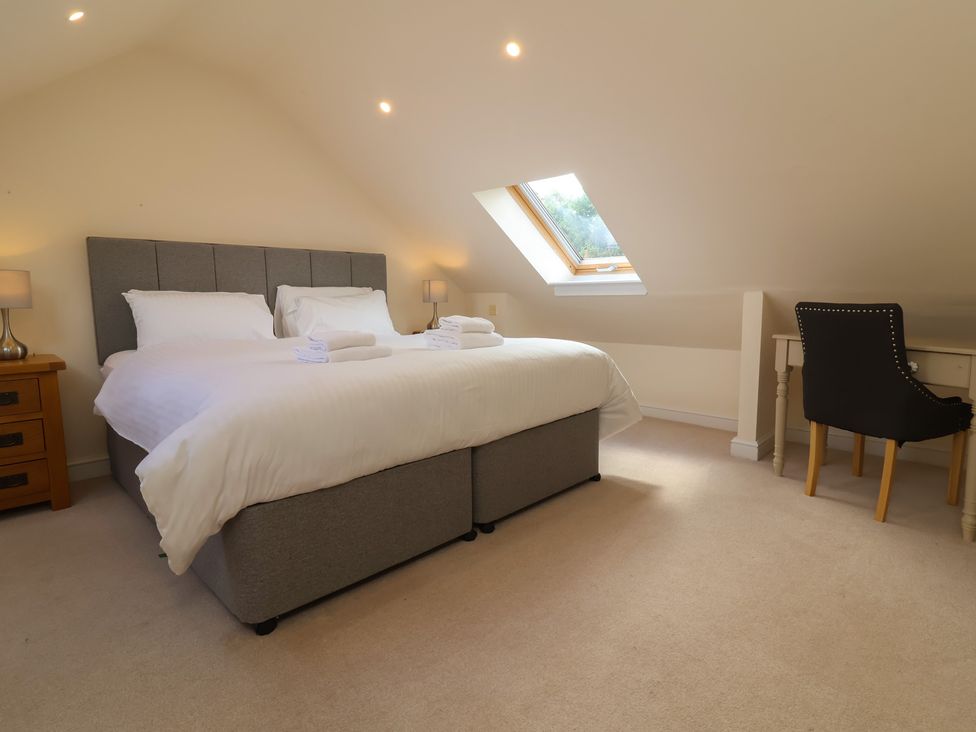 A bedroom with a bed and desk at The Old Byres in Washford near Watchet
