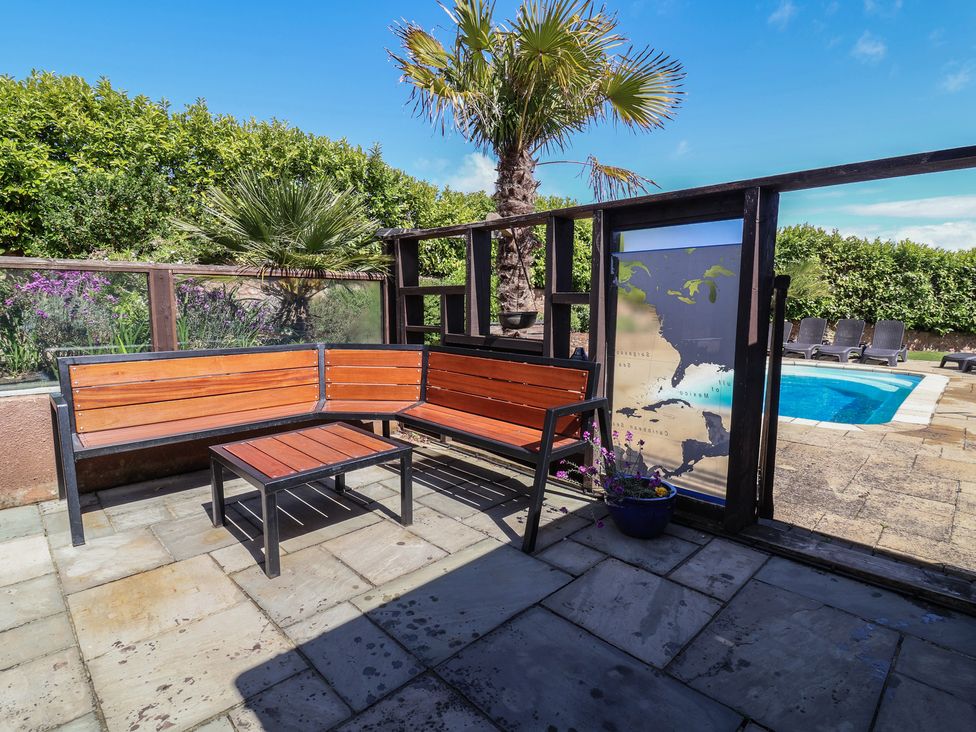 An outdoor area with seating and a pool at The Old Byres in Washford near Watchet
