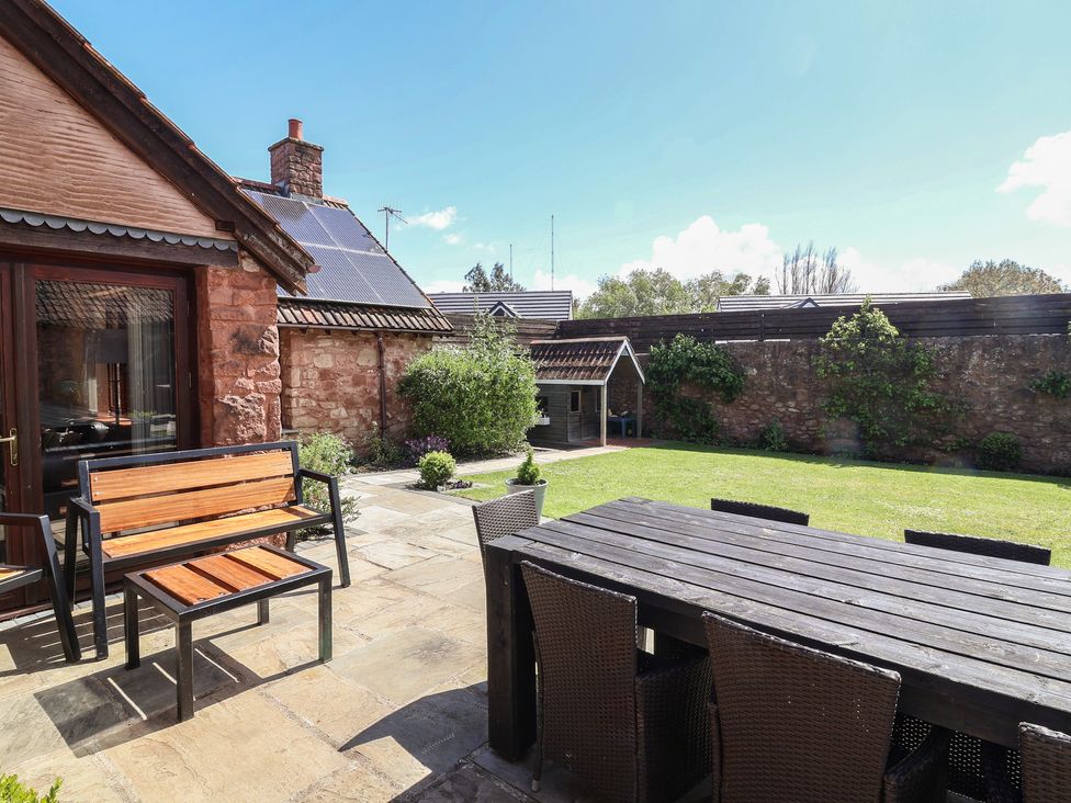 A garden with a table and chairs at The Old Byres in Washford near Watchet