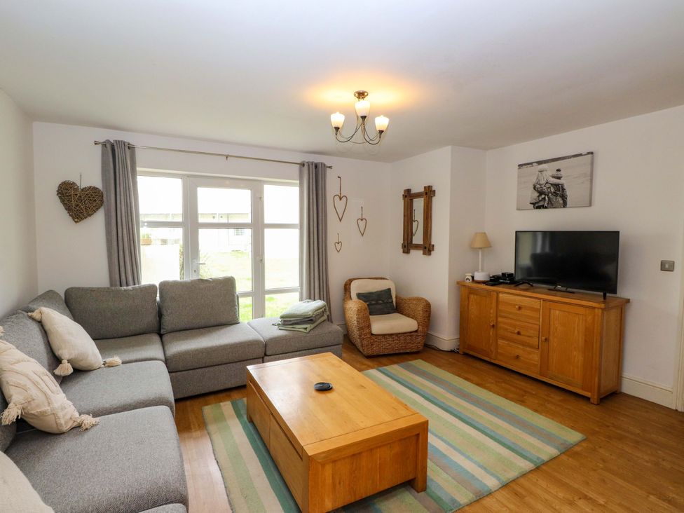 A living room with a sofa and television at The Bungalow in Morfa Nefyn near Pwllheli