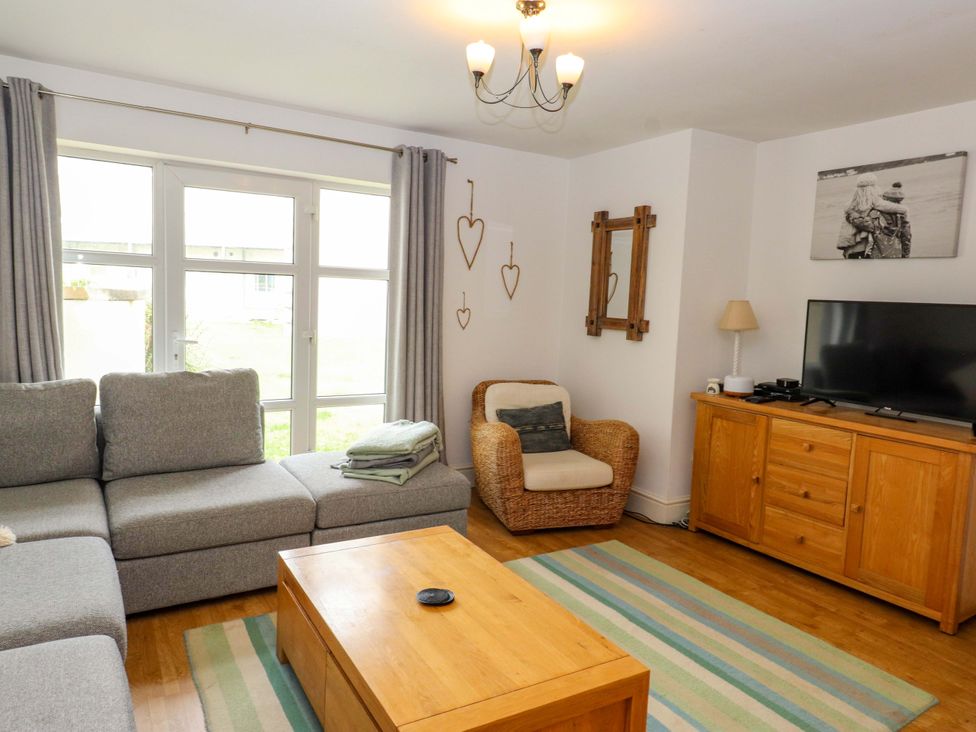 A living room with a sofa and television at The Bungalow in Morfa Nefyn near Pwllheli
