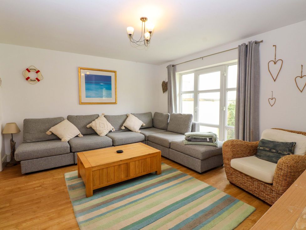 A living room with a gray sofa and wooden coffee table at The Bungalow in Morfa Nefyn near Pwllheli