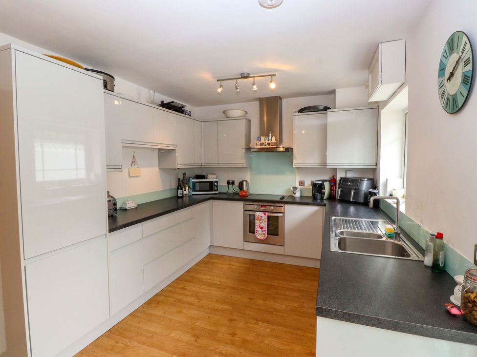 A kitchen with cabinets and appliances at The Bungalow in Morfa Nefyn near Pwllheli