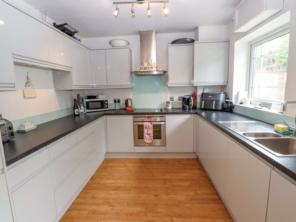 A kitchen with cabinets and appliances at The Bungalow in Morfa Nefyn near Pwllheli