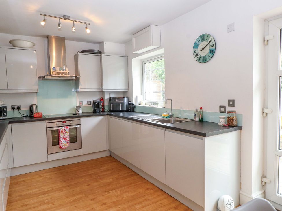 A kitchen with appliances and window at The Bungalow in Morfa Nefyn near Pwllheli