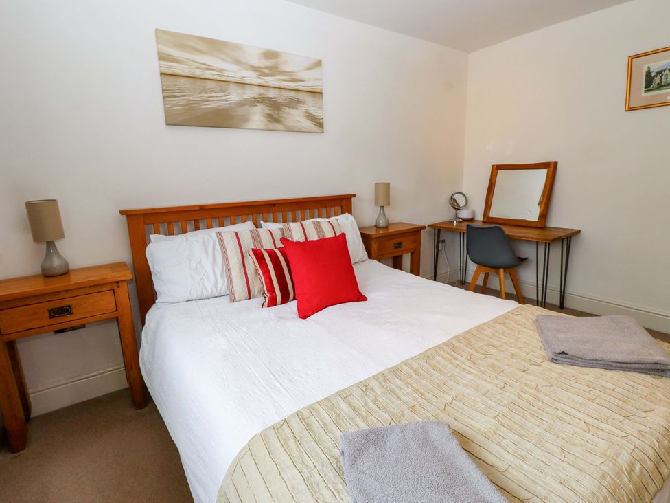 A bedroom with a bed and desk at The Bungalow in Morfa Nefyn near Pwllheli