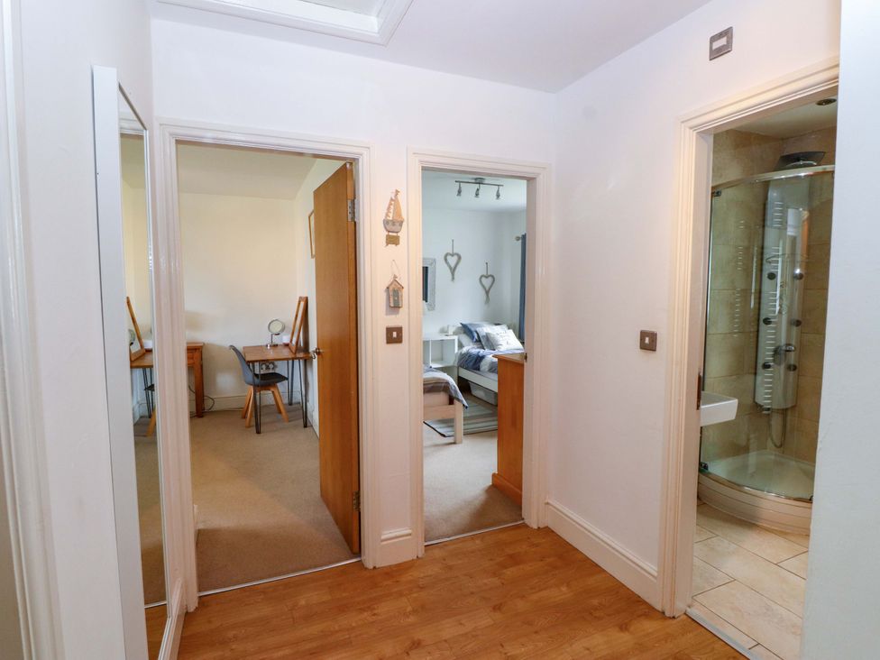 A hallway with doors leading to a bedroom and shower at The Bungalow in Morfa Nefyn near Pwllheli