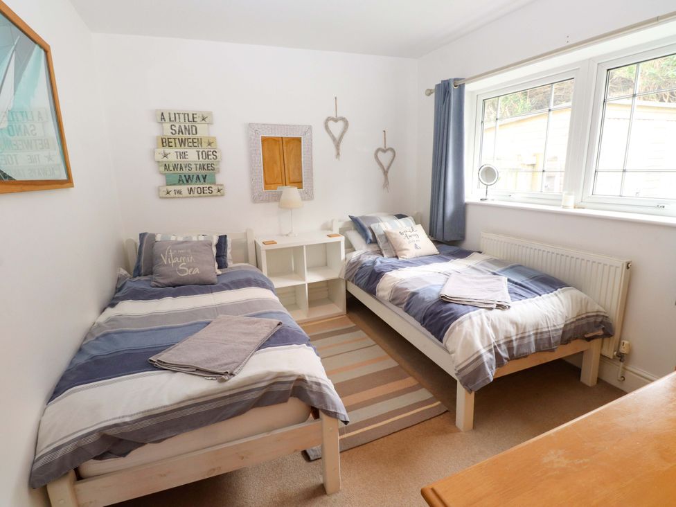 A bedroom with two beds and a lamp at The Bungalow in Morfa Nefyn near Pwllheli