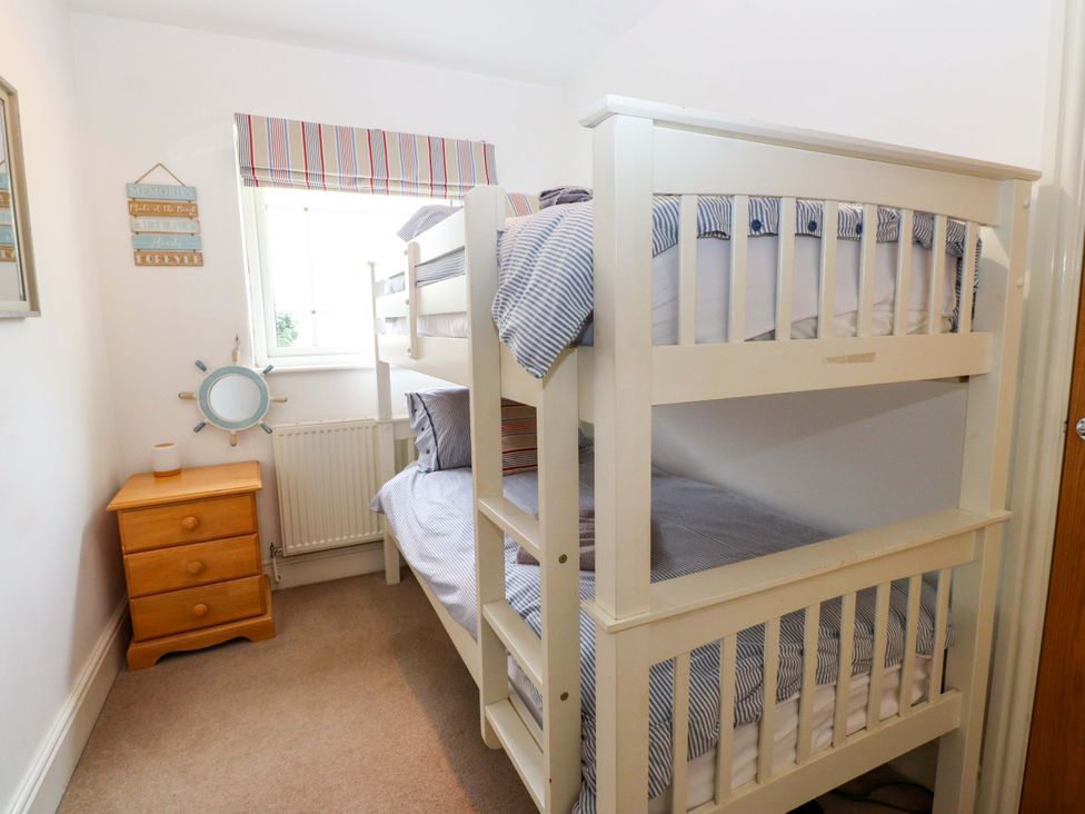 A bedroom with a bunk bed and a chest of drawers at The Bungalow in Morfa Nefyn near Pwllheli