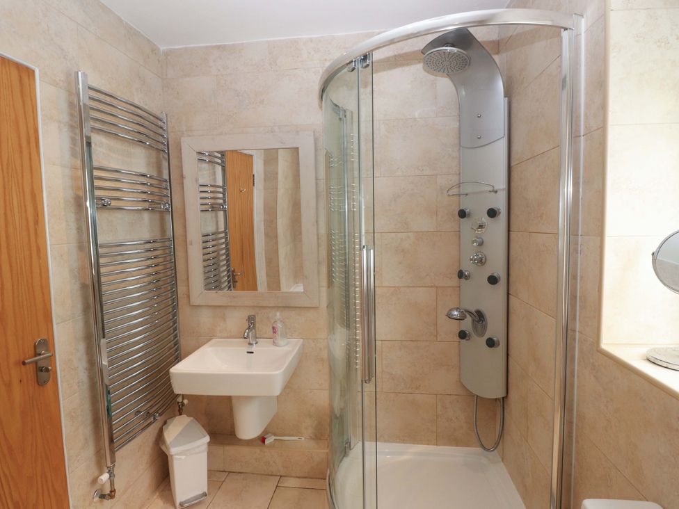 A bathroom featuring a shower, sink, and towel rail at The Bungalow in Morfa Nefyn near Pwllheli