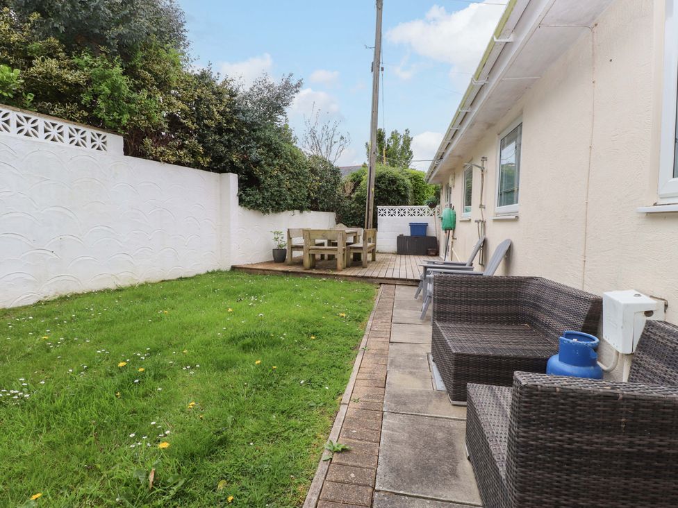 A garden with grass and seating area at The Bungalow in Morfa Nefyn near Pwllheli