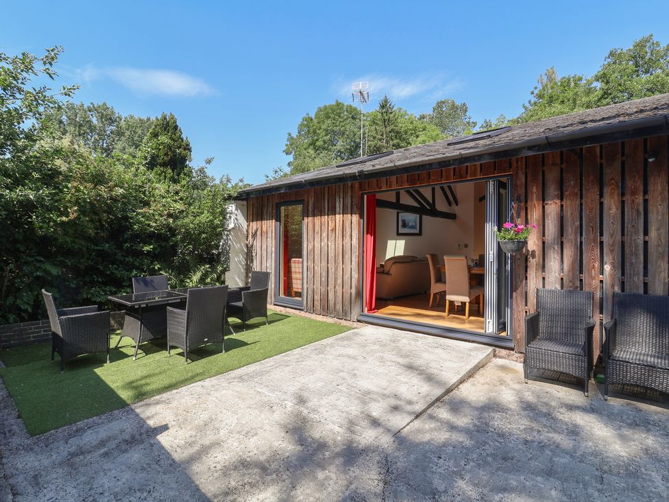 An outdoor area with seating and an open door at Zeal Cottage in Crediton