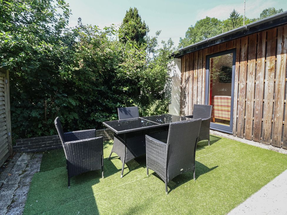An outdoor seating area with a table and chairs at Zeal Cottage in Crediton