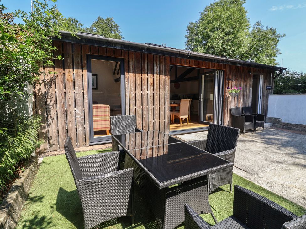 A garden with an outdoor table and chairs at Zeal Cottage in Crediton