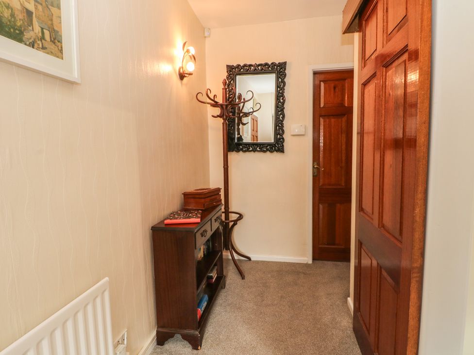 A hallway with a mirror and coat rack at West End House in Thornton, West Yorkshire