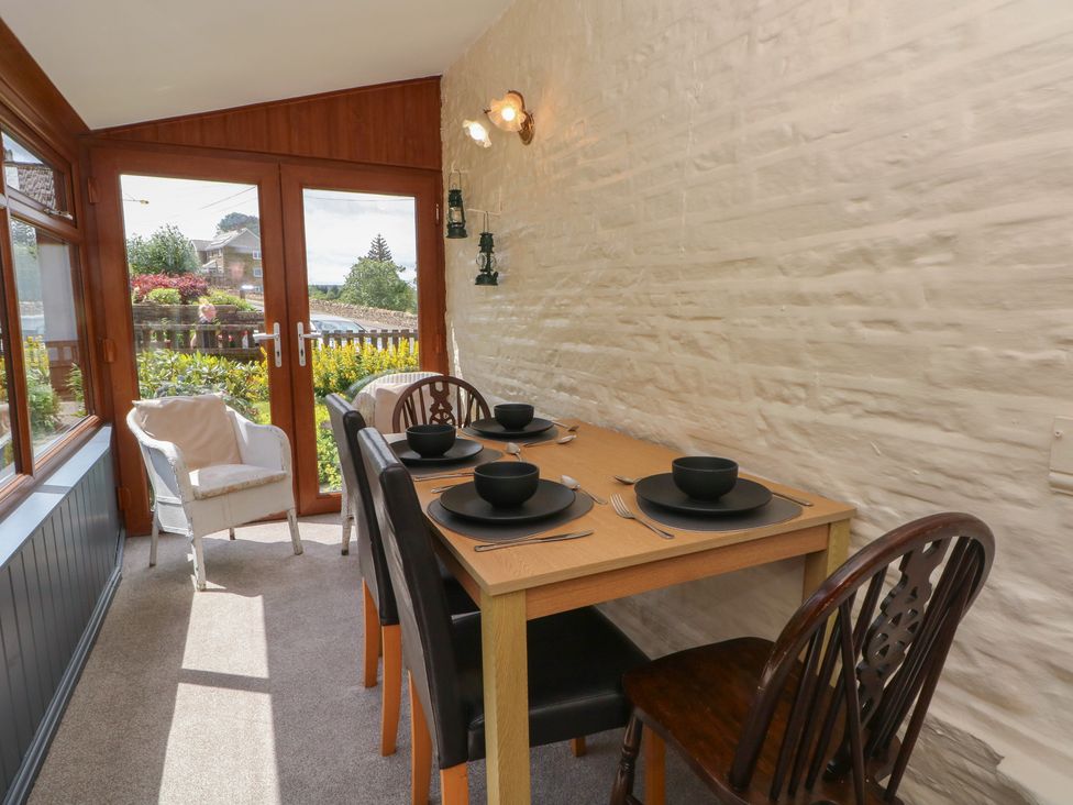 A dining room with a table set for four at West End House Thornton, West Yorkshire