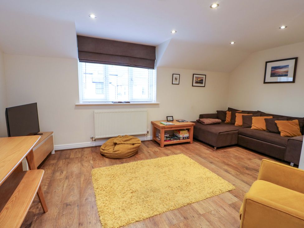 A living room with a sofa and television at Y Enciliad in Rhosneigr