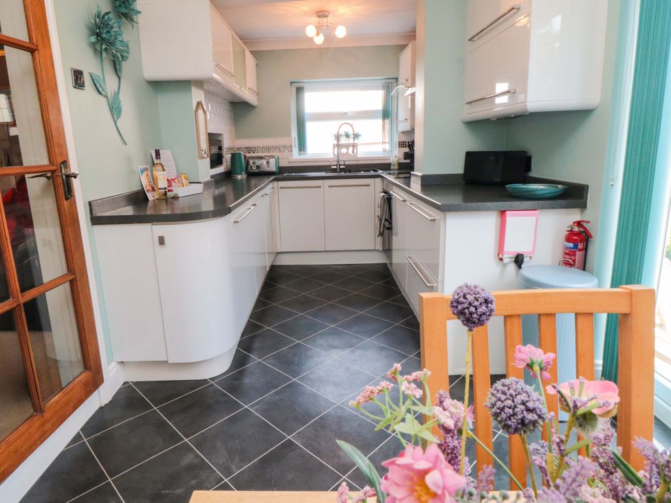 A kitchen with countertop, sink, and kitchen cabinets at Sands End Cottage in Marske-by-the-Sea