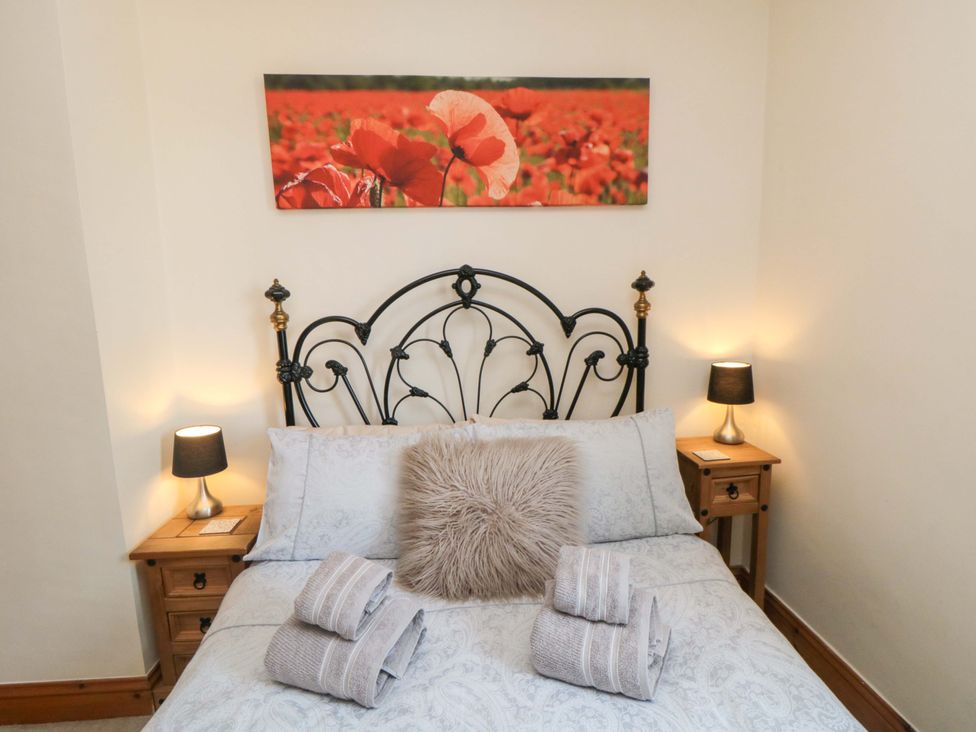 A bedroom with a bed and bedside tables at Sands End Cottage in Marske-by-the-Sea