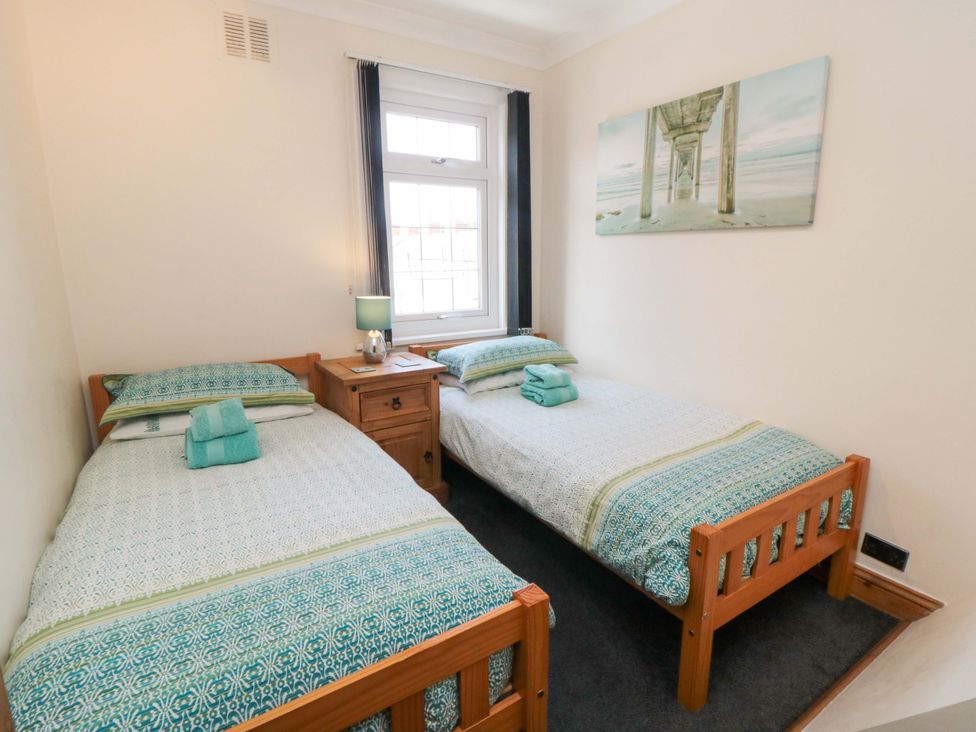 A bedroom with two beds and a lamp at Sands End Cottage in Marske-by-the-Sea