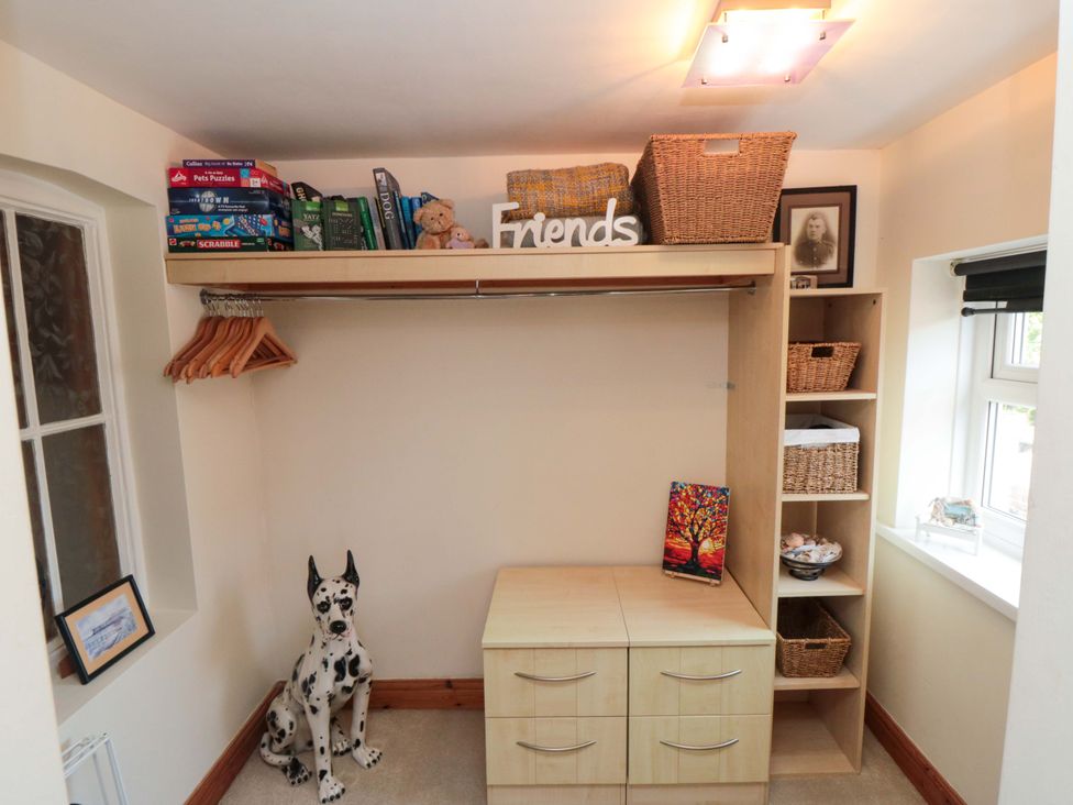 A closet with shelving, storage baskets and a dog statue at Sands End Cottage in Marske-by-the-Sea