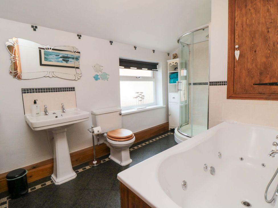 A bathroom with a sink, toilet, and shower at Sands End Cottage in Marske-by-the-Sea