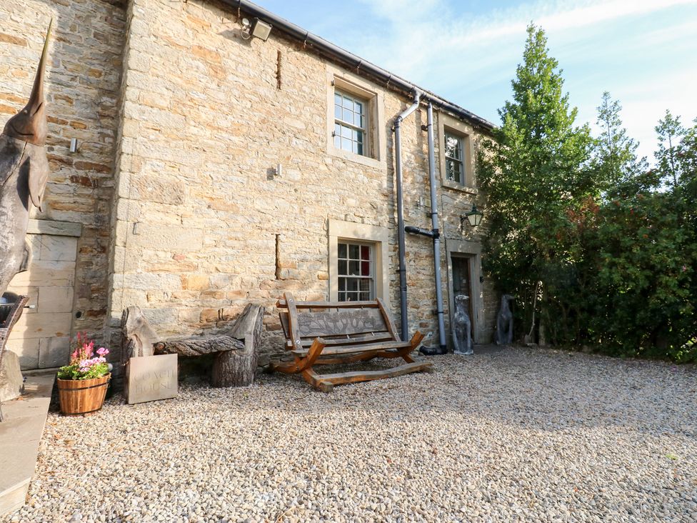 An outdoor area with a stone wall and a wooden bench at 2 The Coach House Romaldkirk near Middleton-in-Teesdale