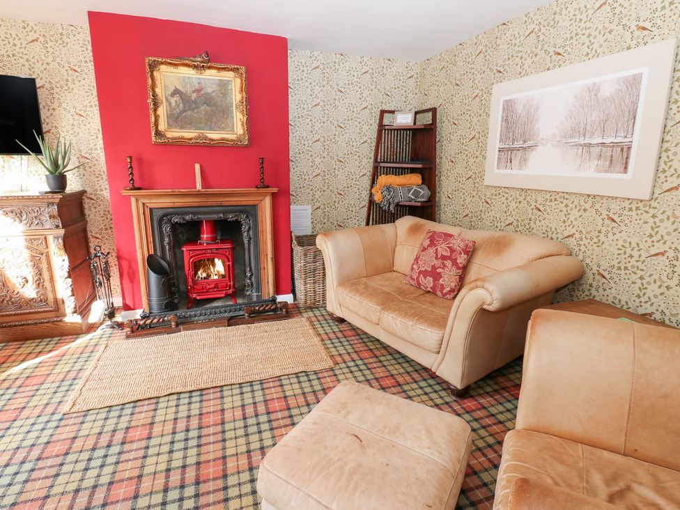 A living room with a fireplace and sofa at 2 The Coach House in Romaldkirk near Middleton-in-Teesdale